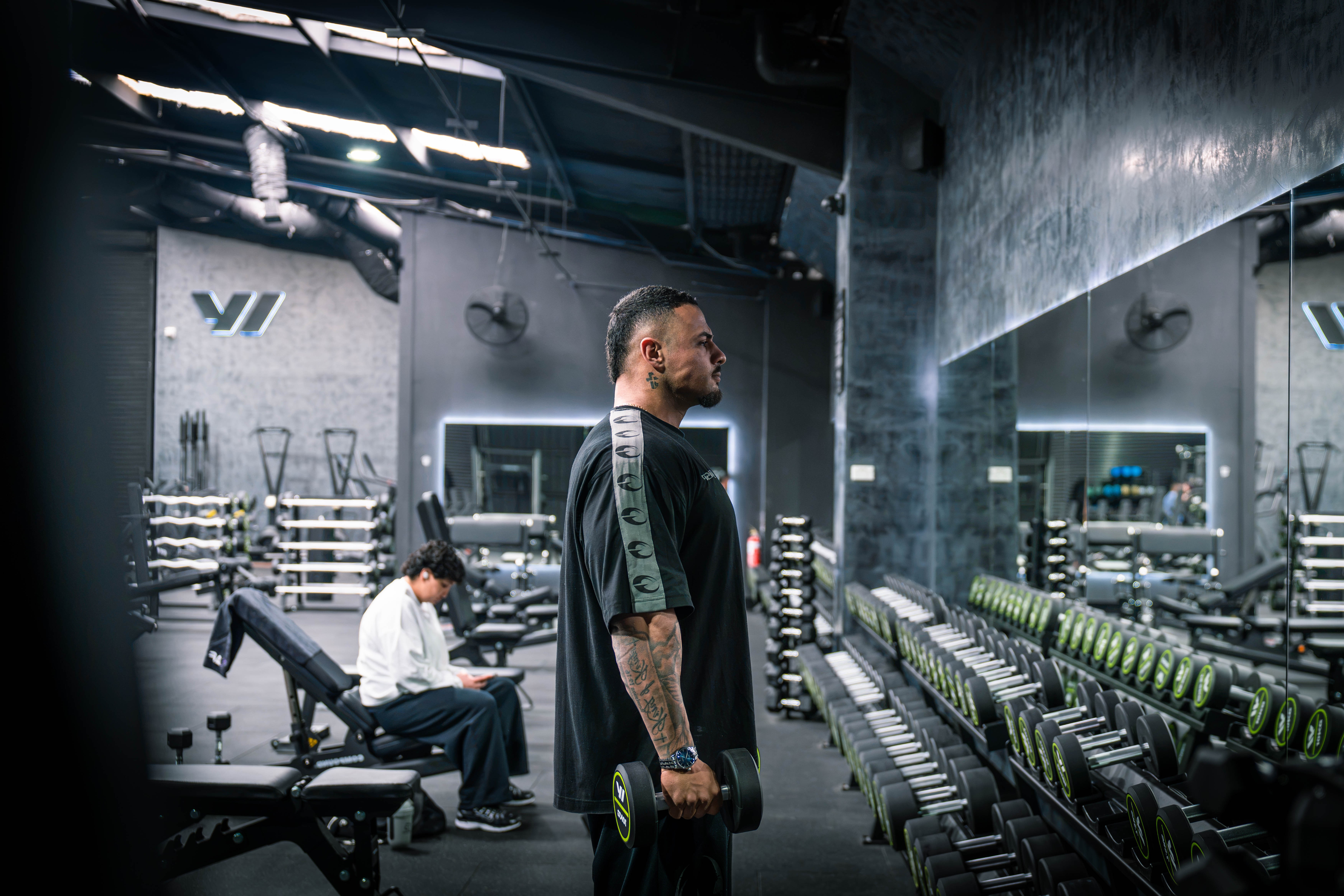 Angelo Yazbek standing with dumbbells in the gym